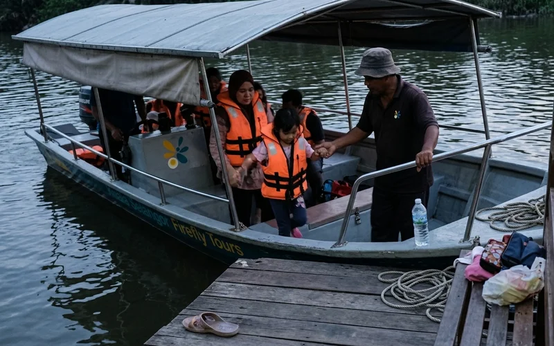A family in life jackets boarding a covered river boat in the evening