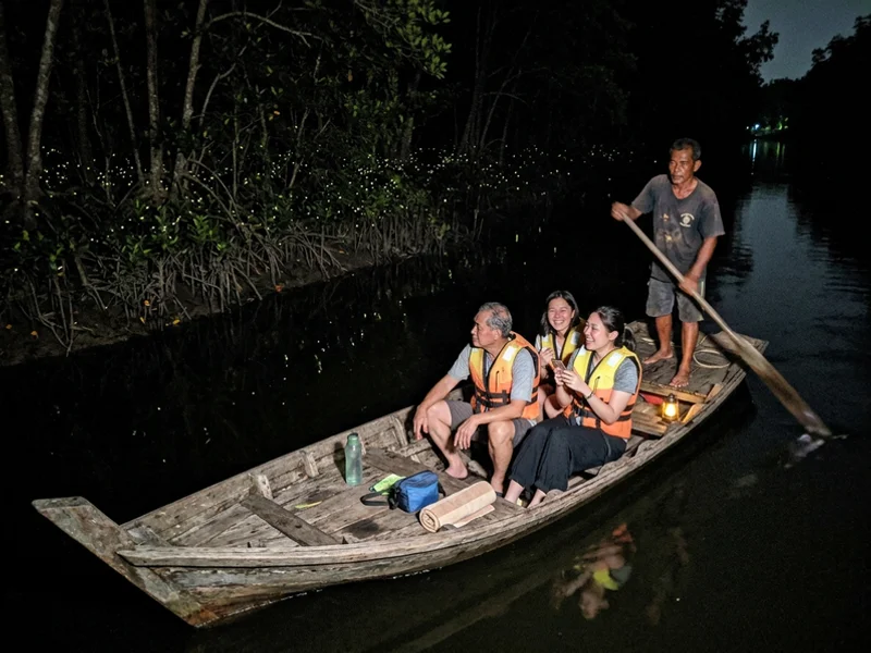 A traditional paddle sampan drifting on the dark river at Kampung Kuantan