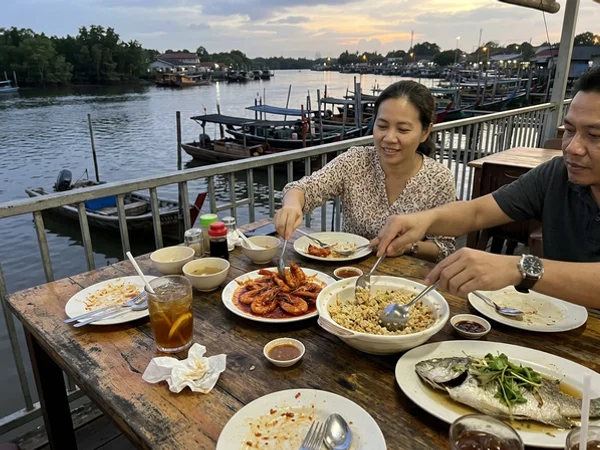 A shared seafood dinner on a table by the Selangor River at dusk