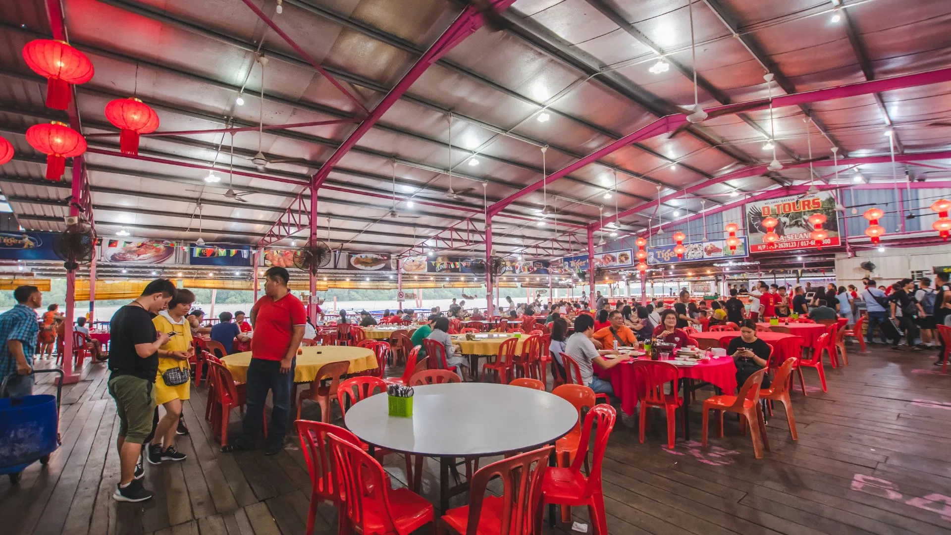 The riverside seafood restaurant hall at Pasir Penambang filling up before the cruise